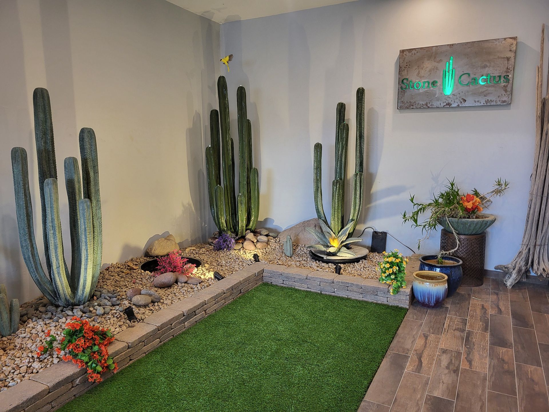 A room filled with cactus , rocks , and potted plants.