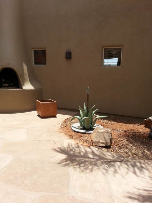 A patio with a fireplace and a potted plant