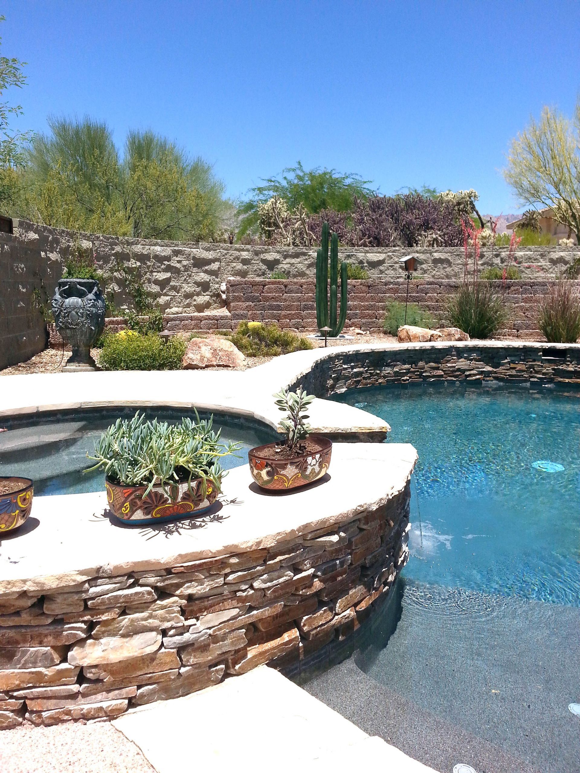 A swimming pool with a stone wall surrounding it