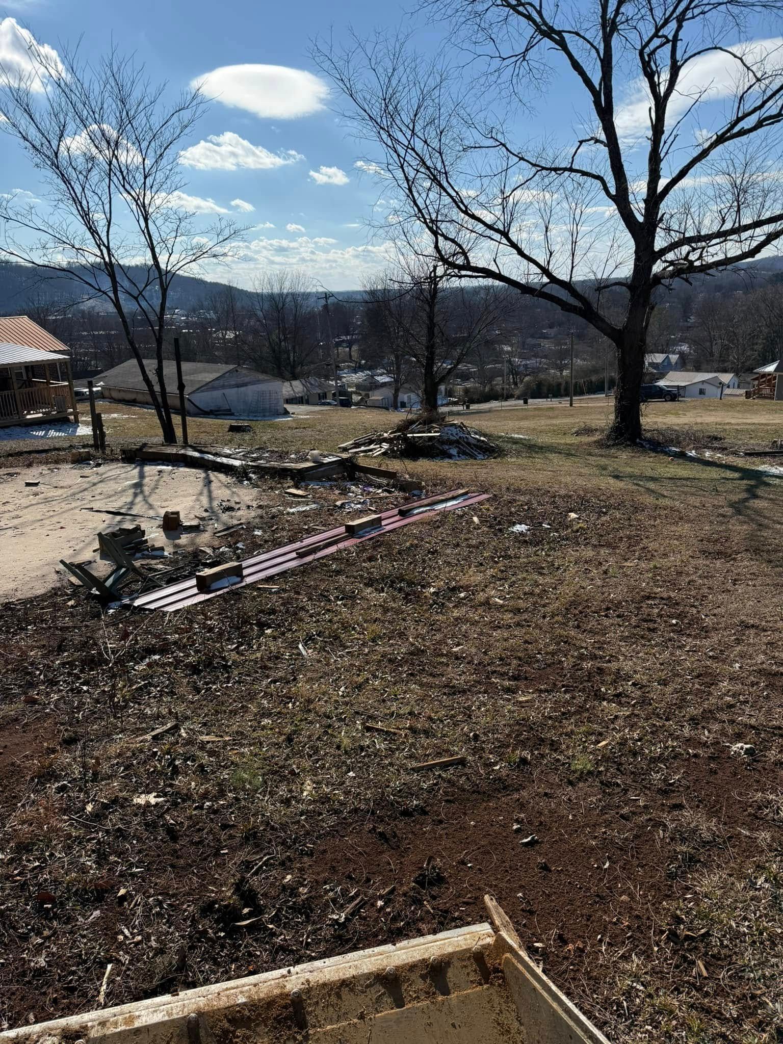 There is a lot of dirt in the middle of a field with a tree in the background.