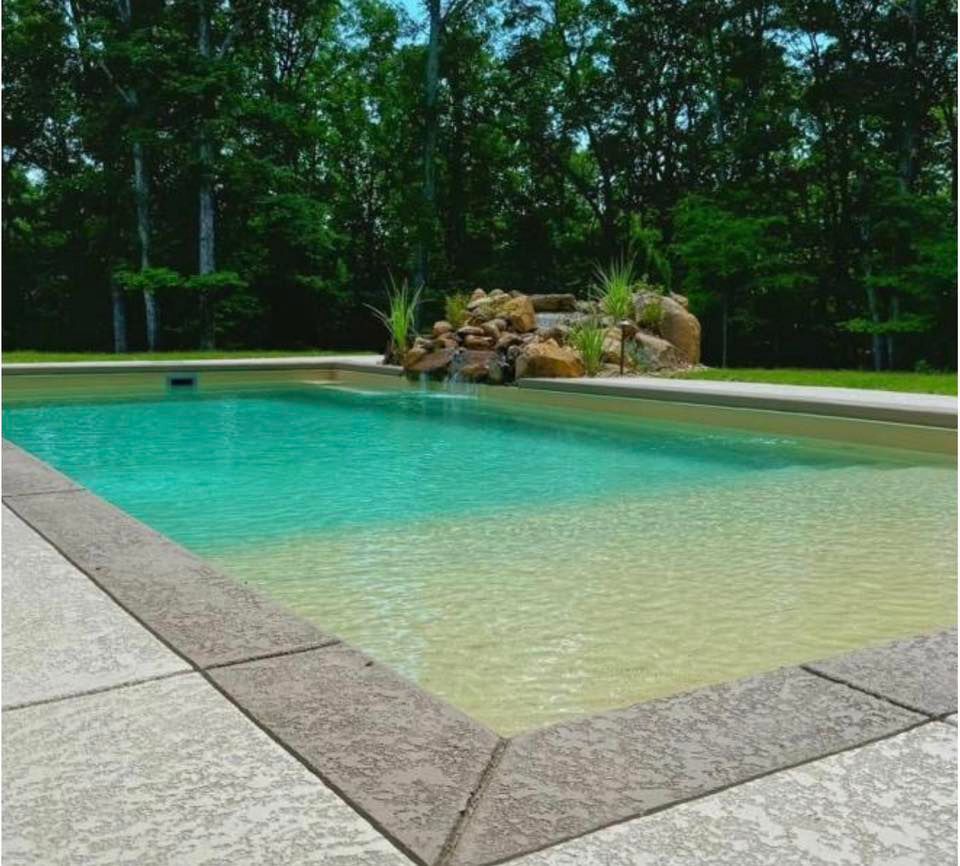 A large swimming pool with trees in the background