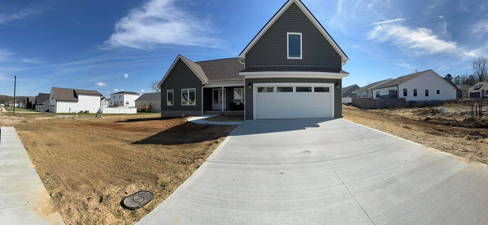 A house with a garage and a driveway in front of it.
