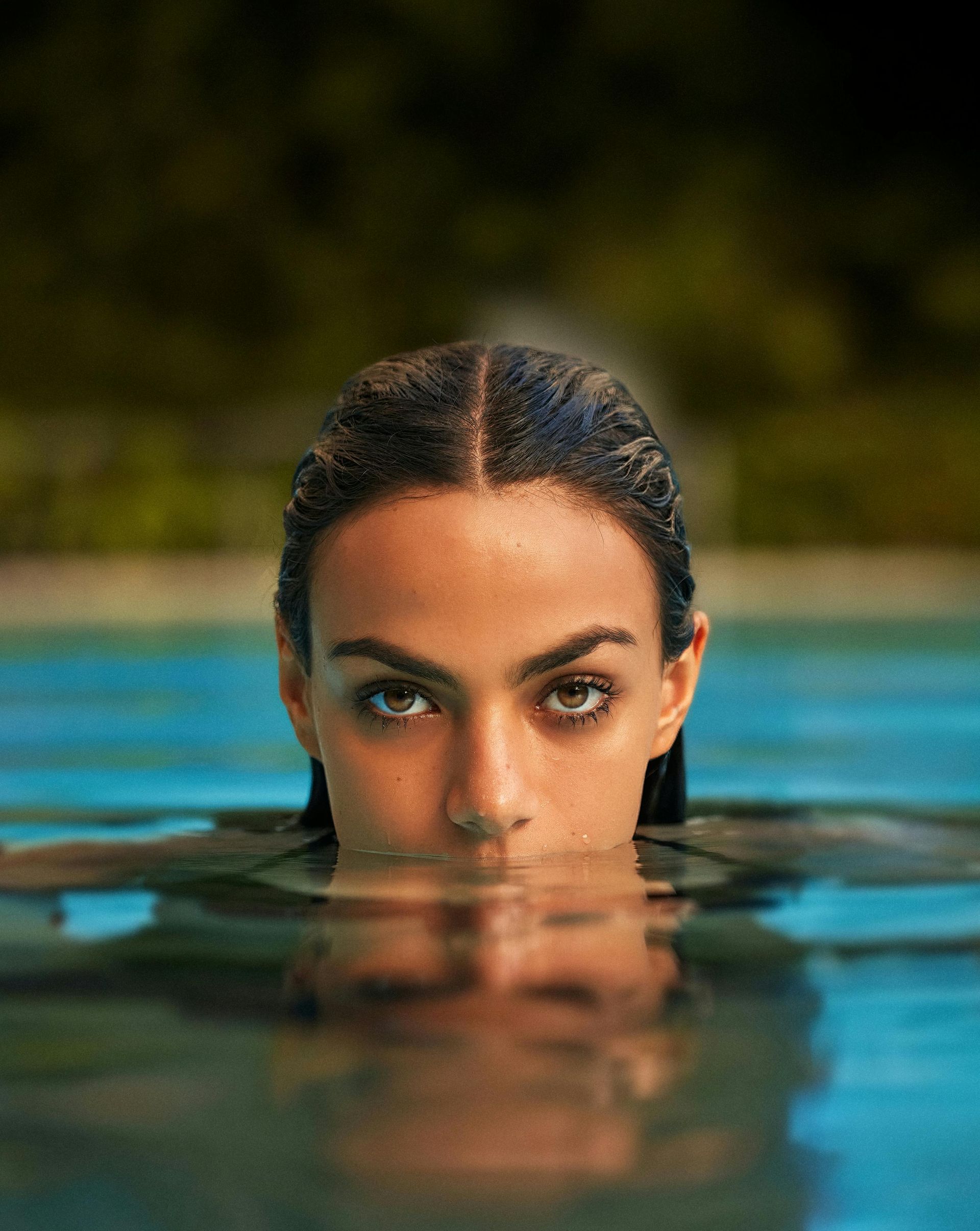 A woman is swimming in a pool with her face in the water.