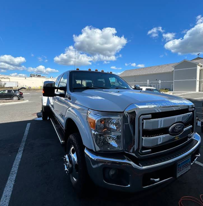 A silver ford truck is parked in a parking lot