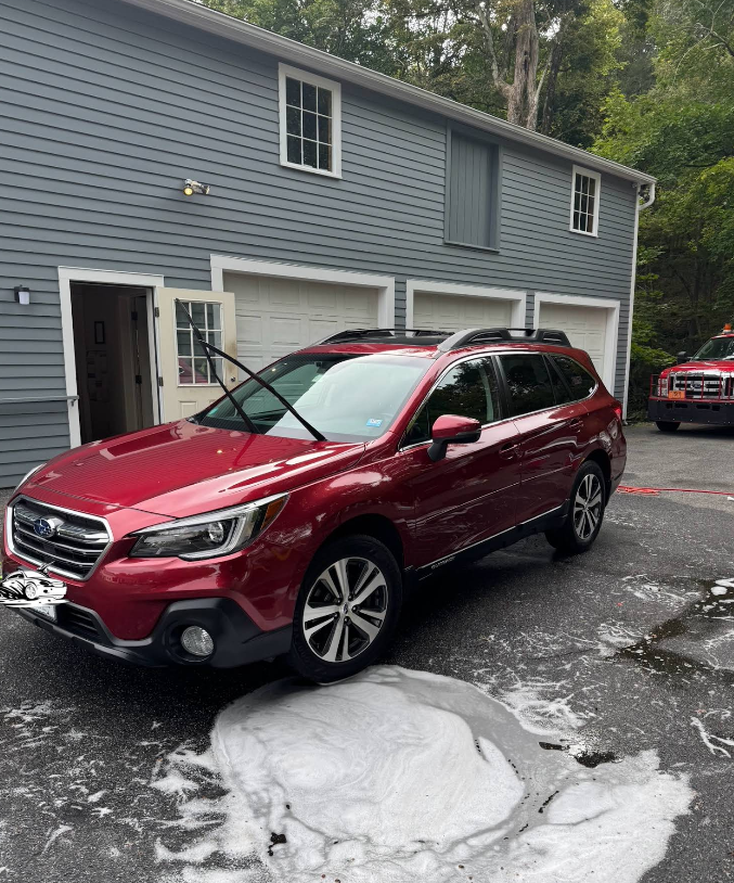 A red suv is parked in front of a house