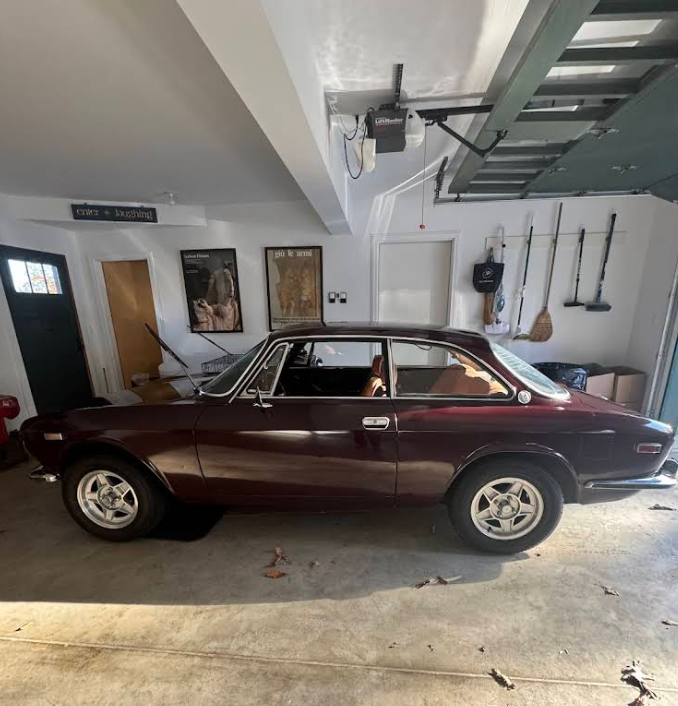 A burgundy car is parked in a garage