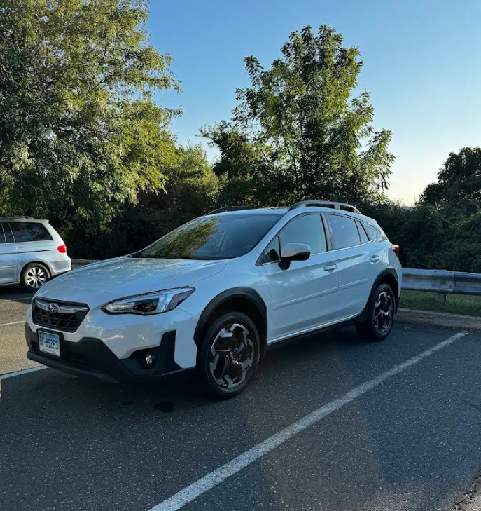A white suv is parked on the side of the road.