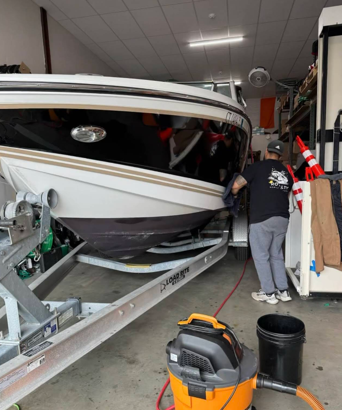 A man is working on a boat in a garage