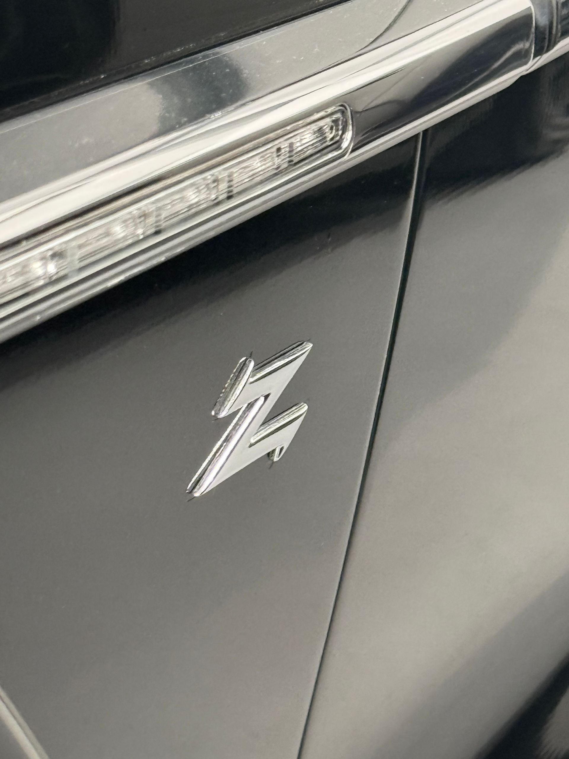 A close up of a black car with a z logo on the side