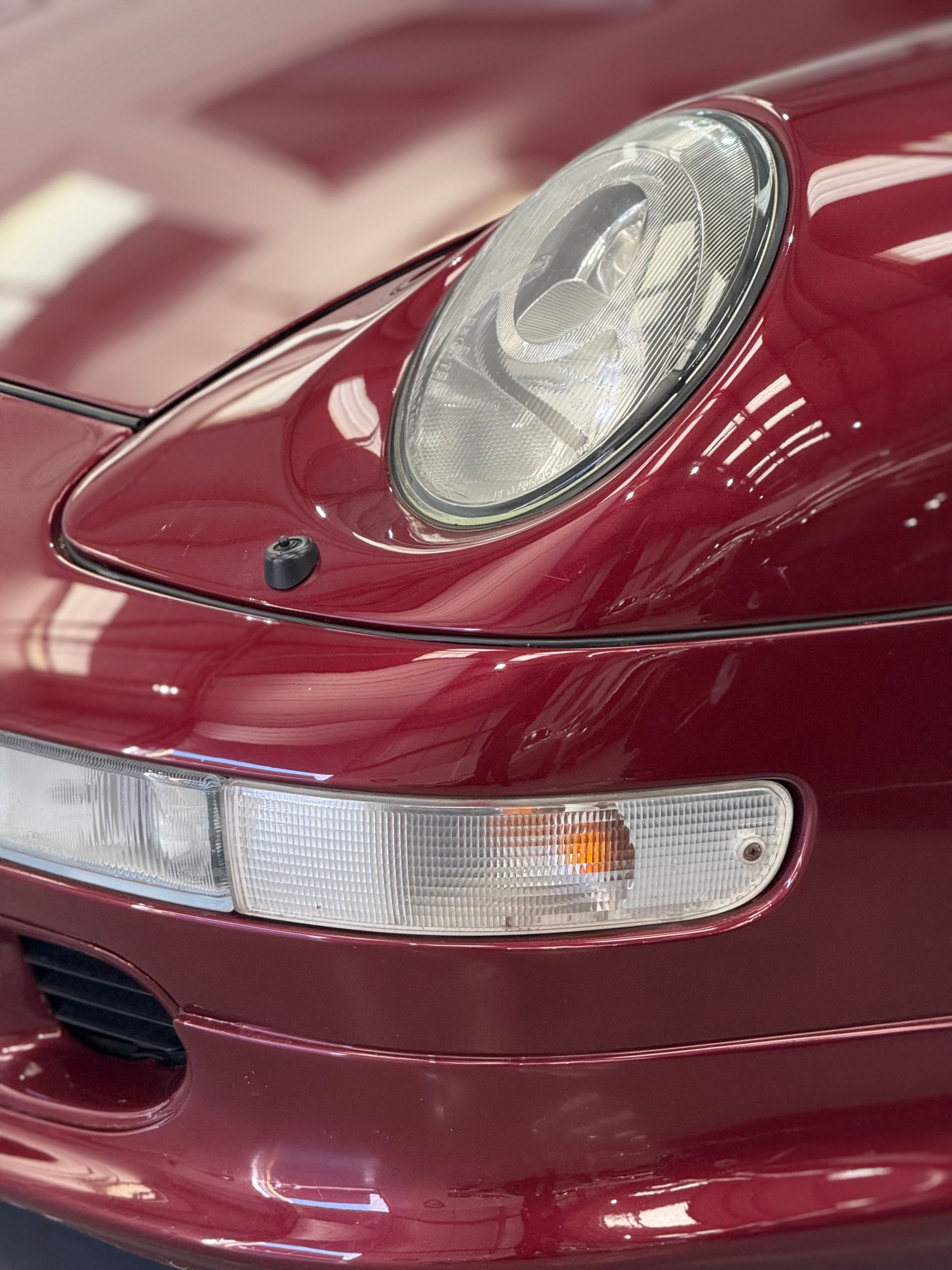 A close up of a red car 's headlight