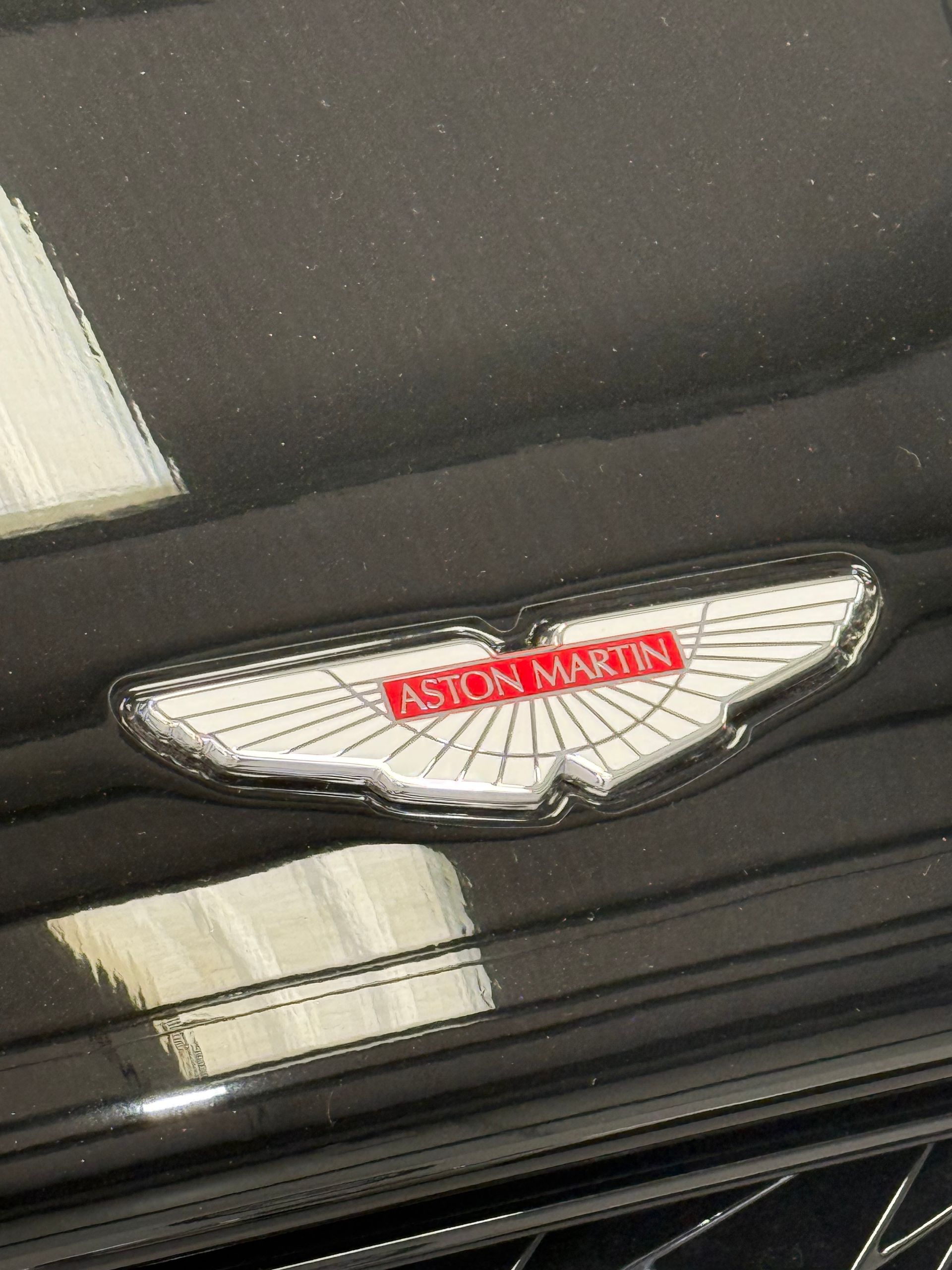 A close up of an aston martin emblem on a black car