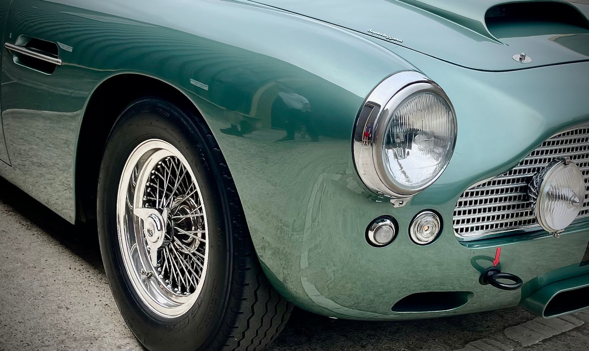 A green car is parked on the side of the road