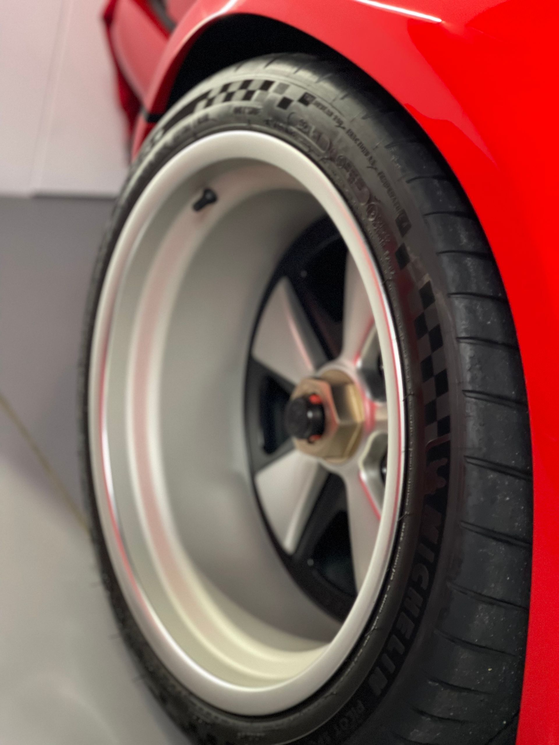 A close up of a red car wheel and tire