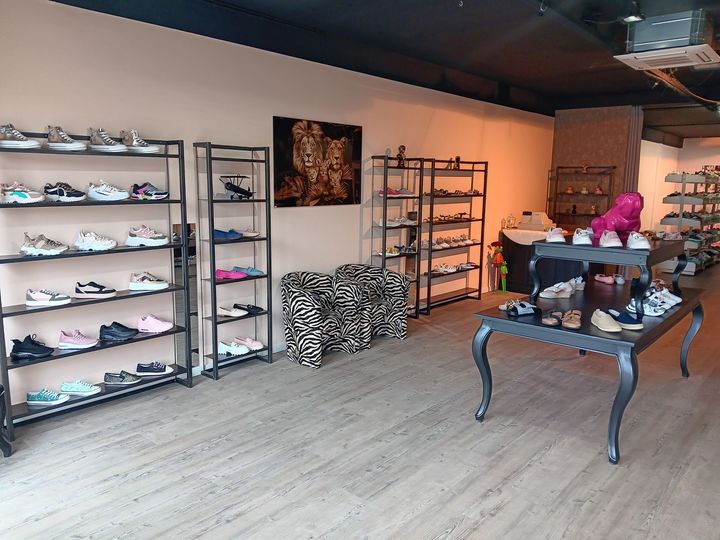 Een winkel vol met veel schoenen en een tafel