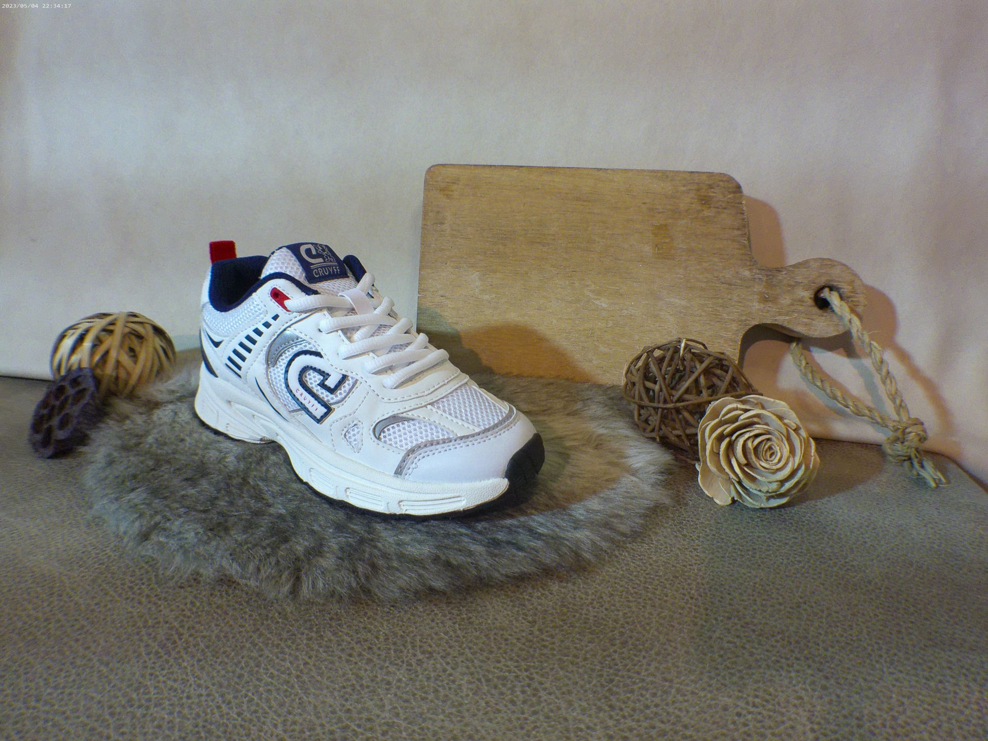 Een paar witte sneakers op een bontkleed.