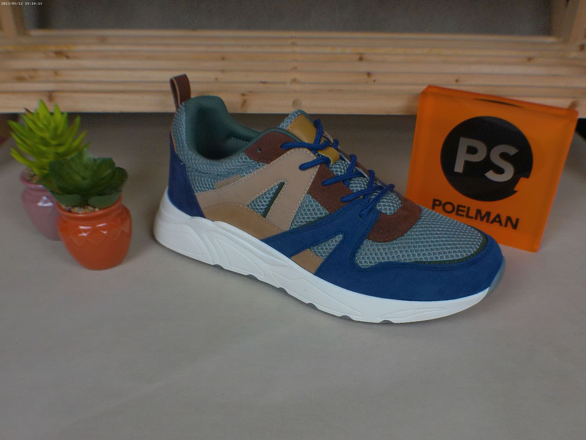 Een paar schoenen naast een doos met de tekst ps