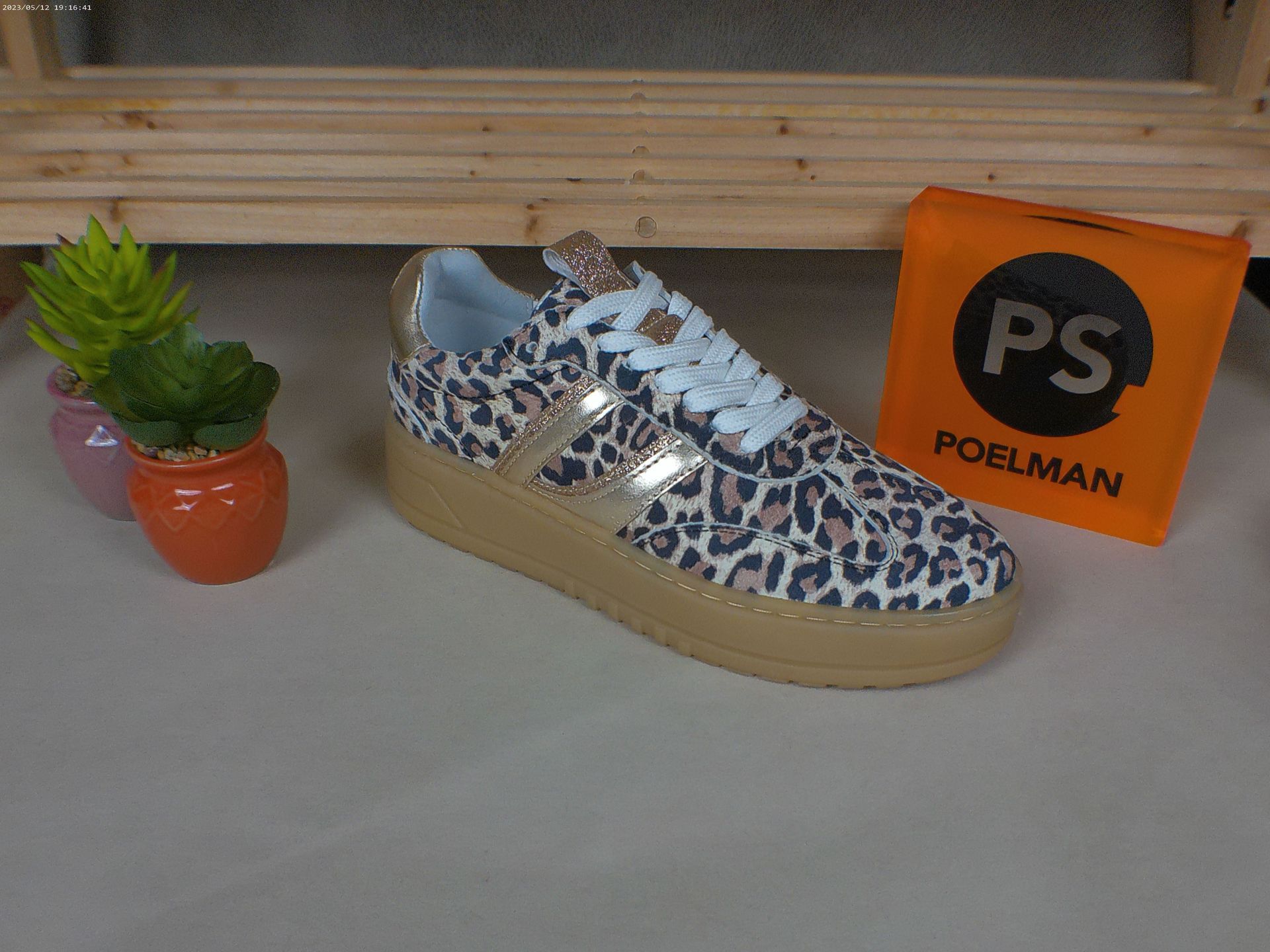 Een paar luipaardprint sneakers naast een PS-box