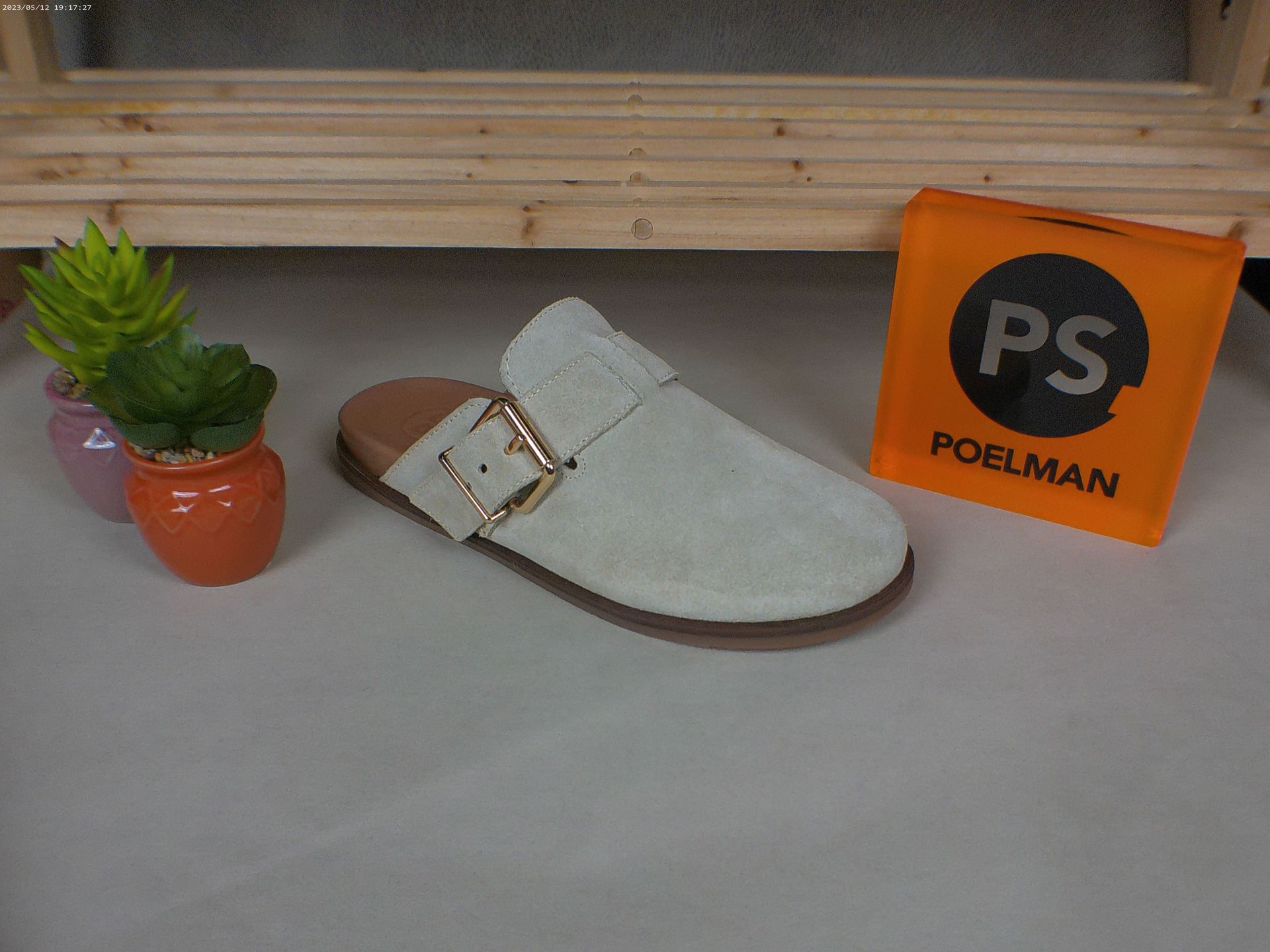 Een paar witte schoenen staat naast een oranje vakje met de tekst ps.