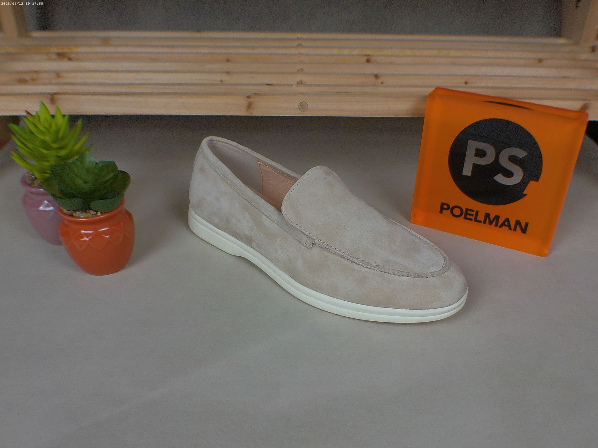 Een paar schoenen staat naast een doos met de tekst ps.
