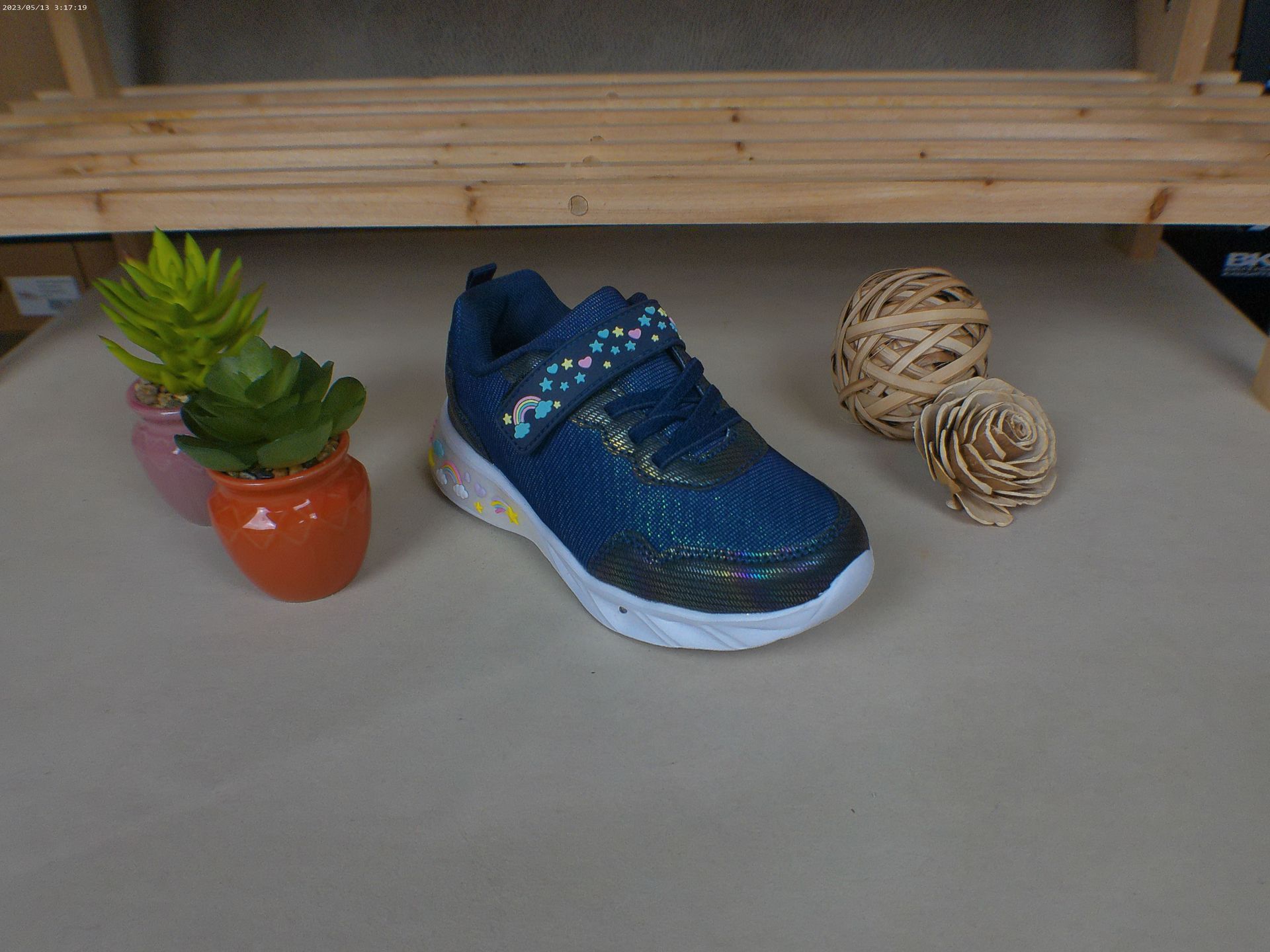 Een paar blauwe schoenen staat op een tafel naast een potplant.
