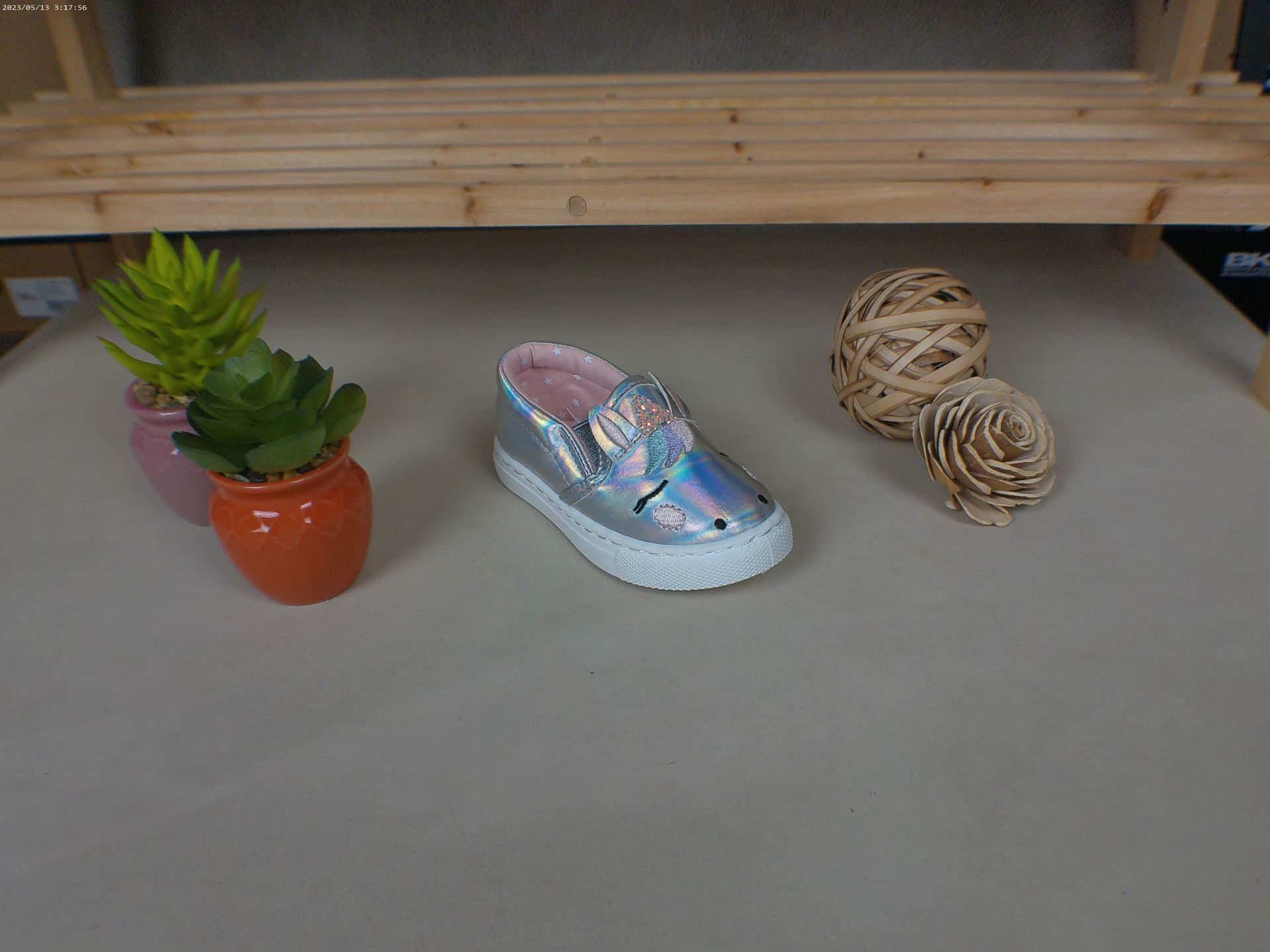 Een paar schoenen staat op een tafel naast een potplant.