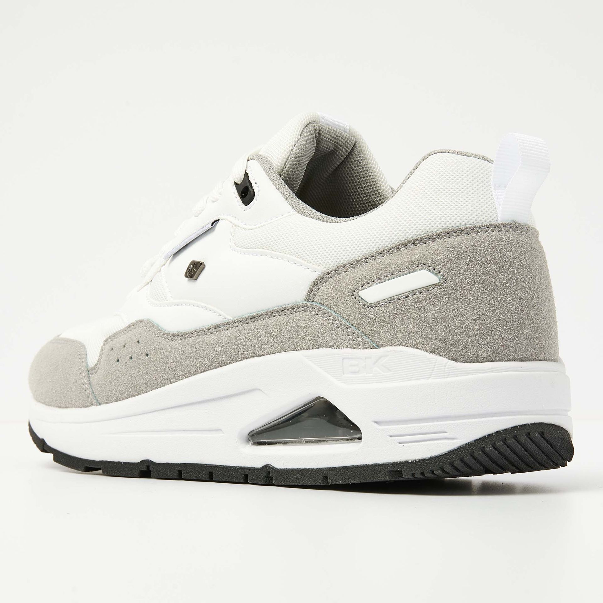 Witte en grijze sportschoen met airsole, mesh-bovenwerk en suède accenten.