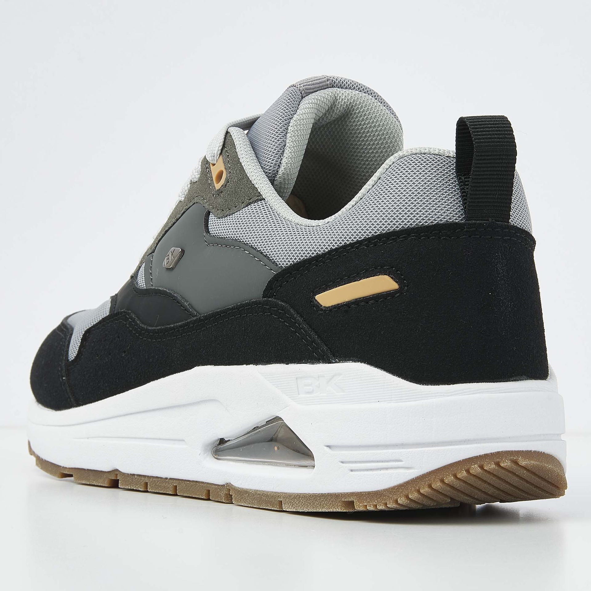 Zwarte, grijze en witte sportschoen met luchtzakjes in de zool.