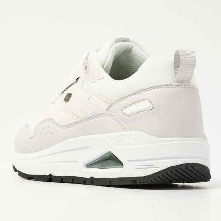 Witte sportschoen met zwarte zool en luchtkussen, neutrale tinten.