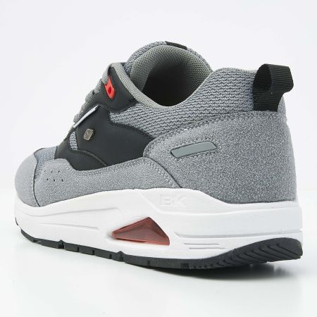 Grijze en zwarte sportschoen met witte tussenzool en rode accenten.