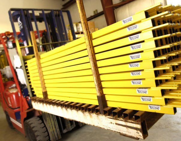 A forklift is carrying a stack of yellow pallets