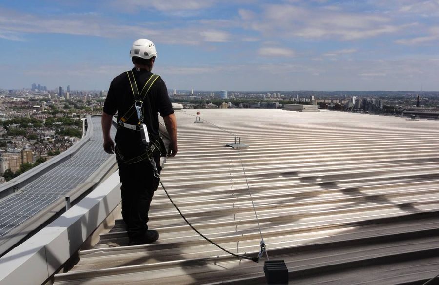 A man standing on top of a building with a city in the background