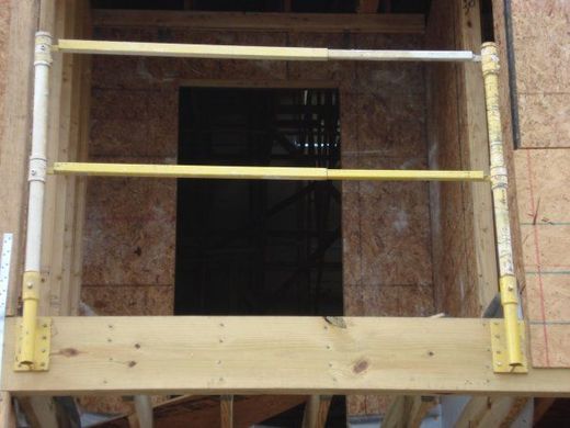 A wooden frame with a yellow railing in front of a door