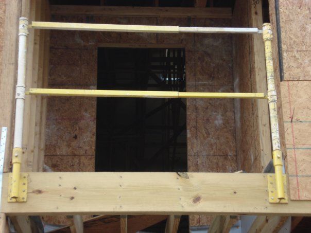 A wooden frame with a yellow railing in front of a door