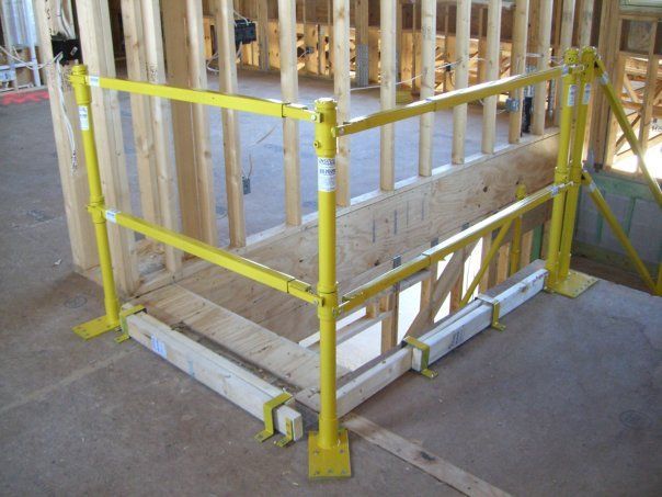 A yellow railing on a wooden wall in a building under construction
