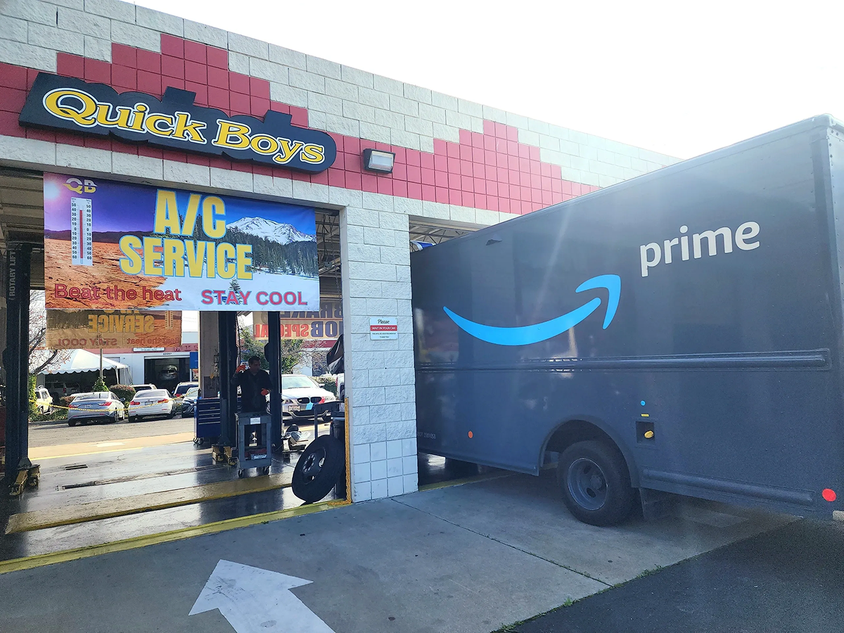 An amazon delivery truck is parked in front of a car wash | Quick Boys Brake & Tune