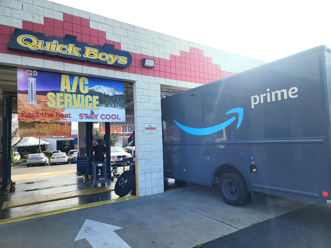 An amazon delivery truck is parked in front of a car wash | Quick Boys Brake & Tune