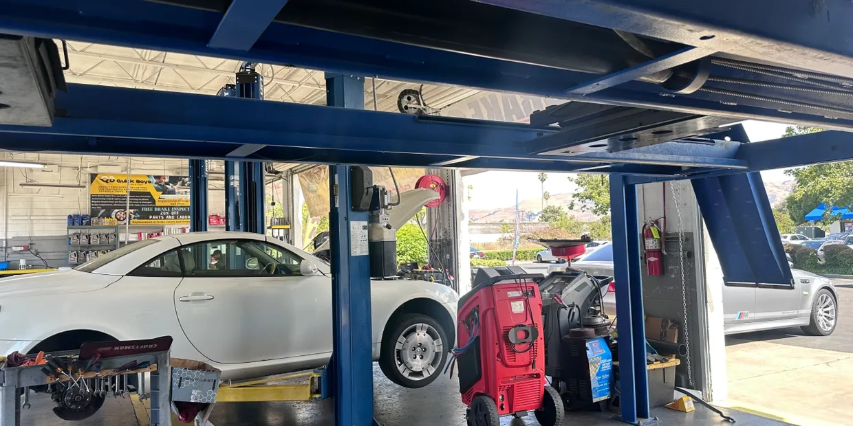 A car is sitting on a lift in a garage | Quick Boys Brake & Tune