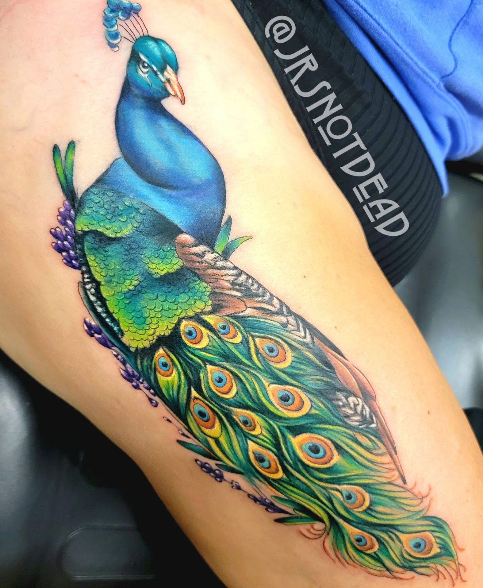 A woman with a tattoo on her arm is covering her face with her hands