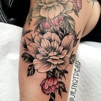 A man with a lot of tattoos on his arms is covering his face with his hands.