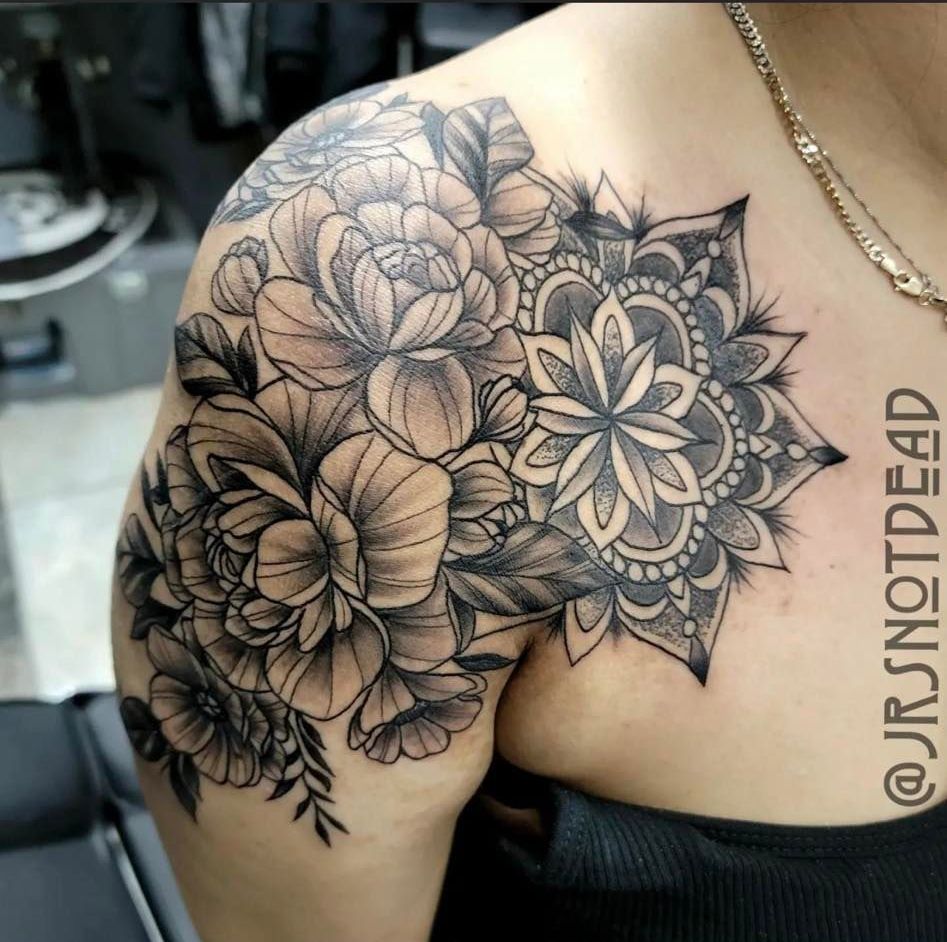 A black and white photo of a person with tattoos on their legs.