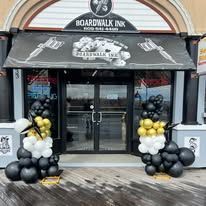 The front of a tattoo shop with balloons in front of it.