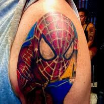 A man has a spiderman tattoo on his shoulder.