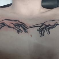 A woman has a tattoo of the creation of adam on her chest.