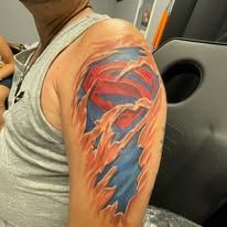 A man has a superman tattoo on his shoulder.