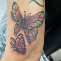A woman has a tattoo of two butterflies on her arm.
