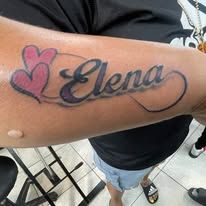 A person has a tattoo of the name elena on their arm.