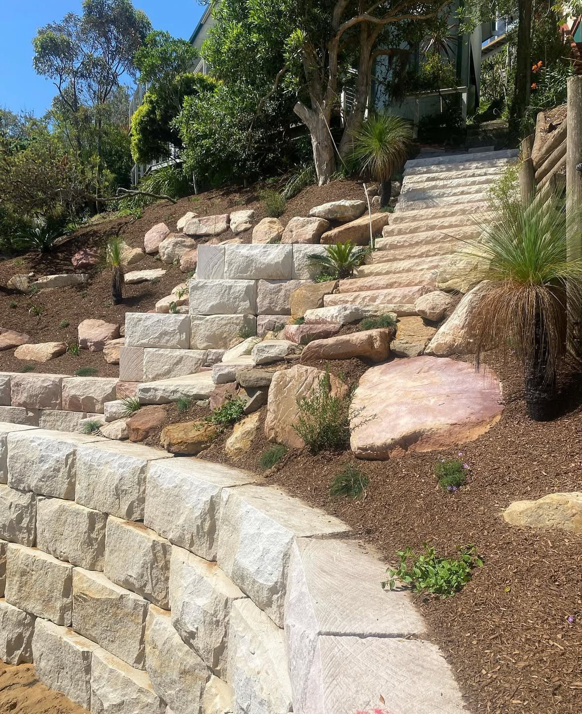 A stone wall with stairs leading up to a house