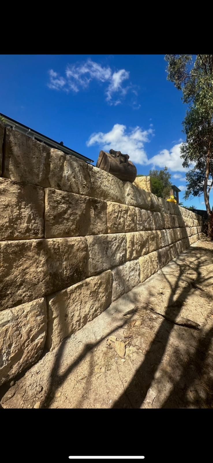 A large stone wall with a blue sky in the background.