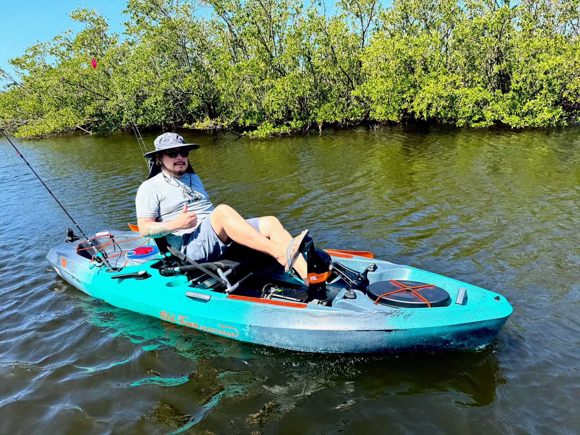 Group of people waving from a pontoon boat on a sunny day at sea.