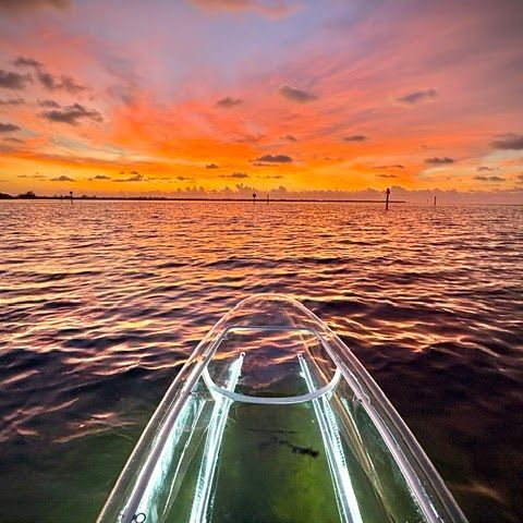 Group of people waving from a pontoon boat on a sunny day at sea.
